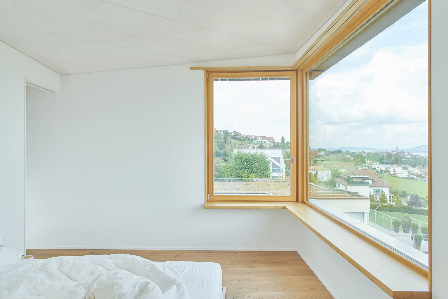 Helles Schlafzimmer mit Eckfenster mit Aussicht