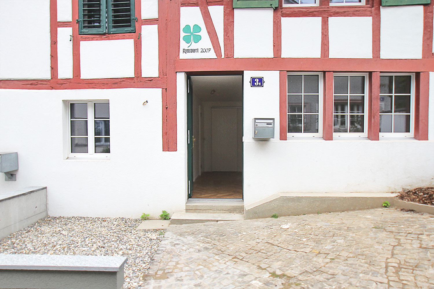 Fassade mit rotem Holz Fachwerk und weissem Putz